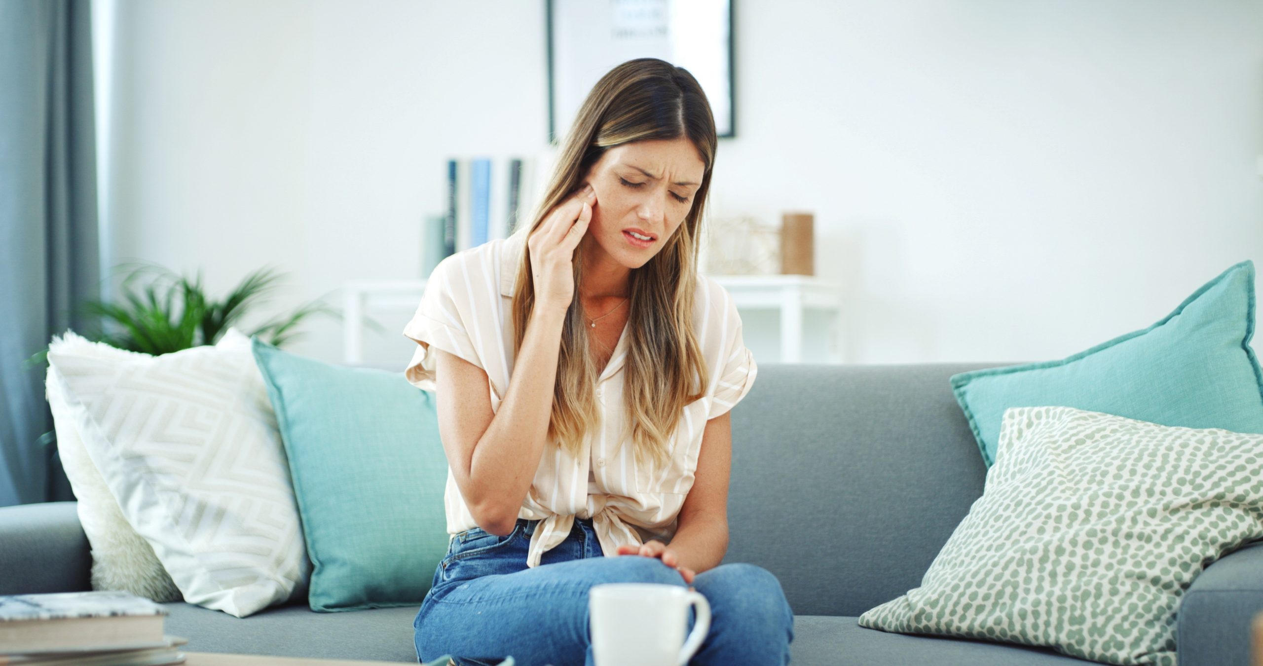 woman sitting down with jaw pain